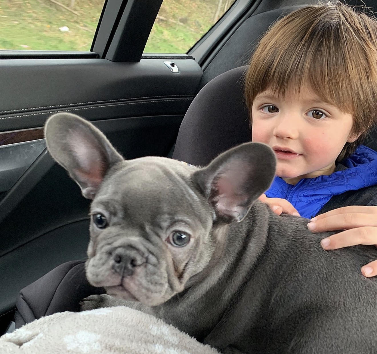 Happy owner hugging her adopted French Bulldog outdoors